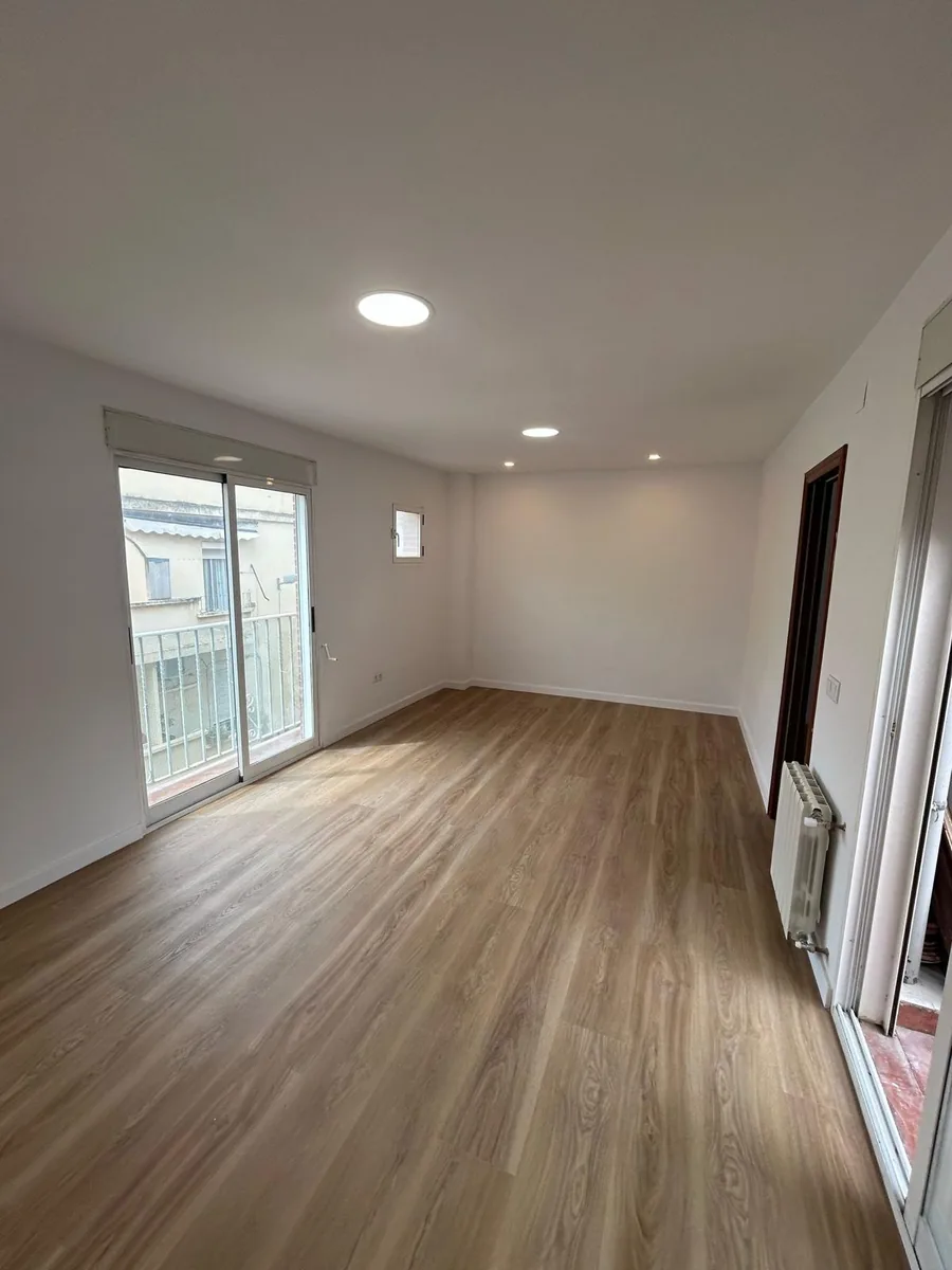 Salón con suelo nuevo tras una reforma integral de piso en Valencia